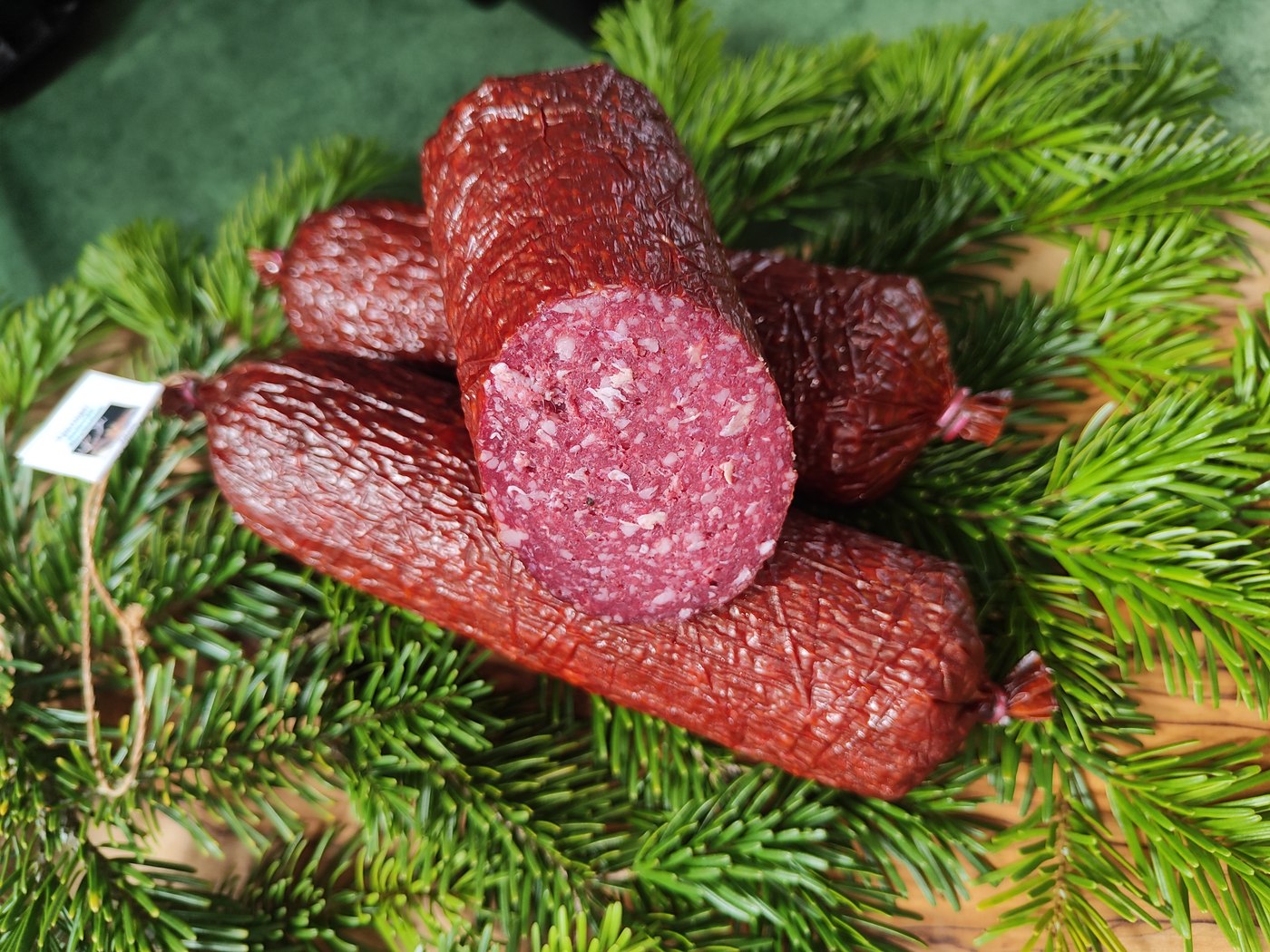Hirschsalami mit Anschnitt auf Tannengrün